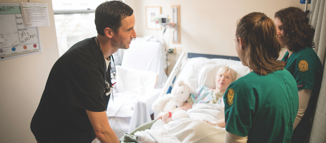 Three CNHS nurses on rounds visiting a elderly patient.