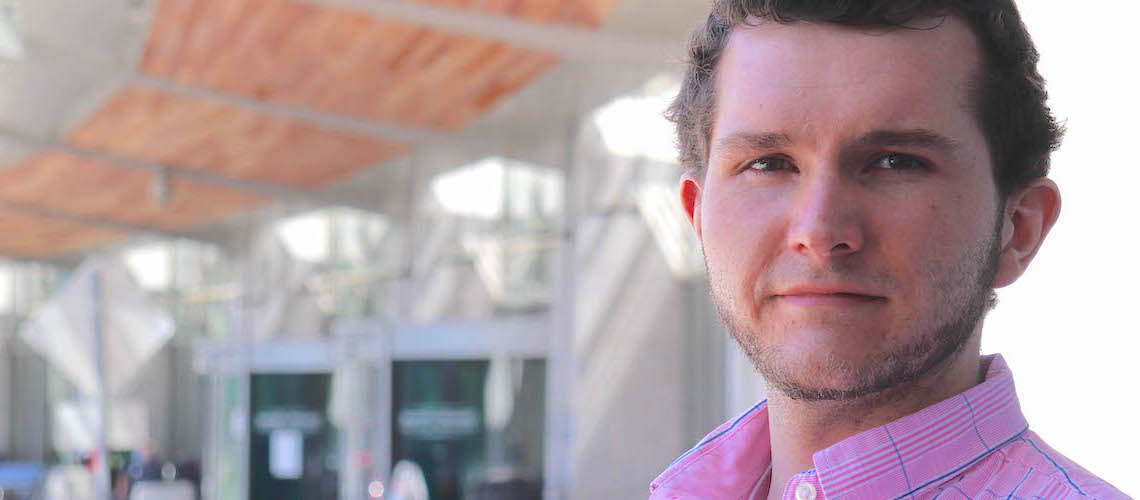 Headshot of Matthew Mugford standing outside the front entrance of the UVM Medical Center.