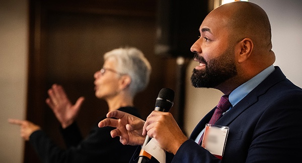 Candid of Health Equity Summit presenter in the foreground with ASL interpreter in the background.