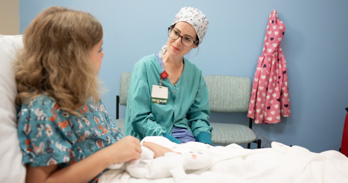 Nurse talking to youg patient in bed