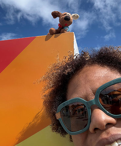 Elizabeth A. Bonney, MD, MPH in front of a colorful wall with stuff dog on top