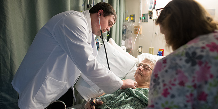 Doctor listening to elderly man's heart with stethoscope