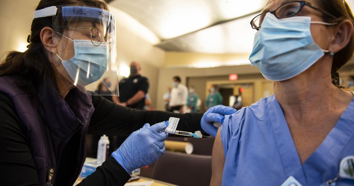Health care provider giving vaccine to UVM Health Network employee