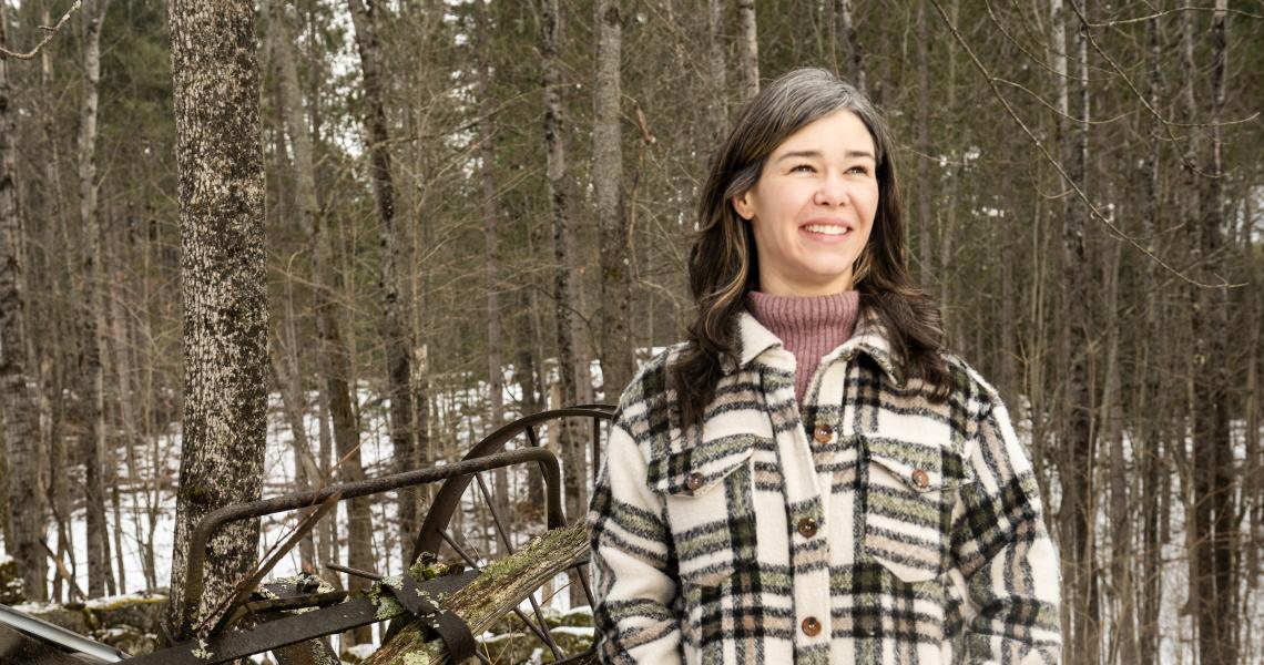 Portrait of Casey Kolb Nava in the woods in winter.