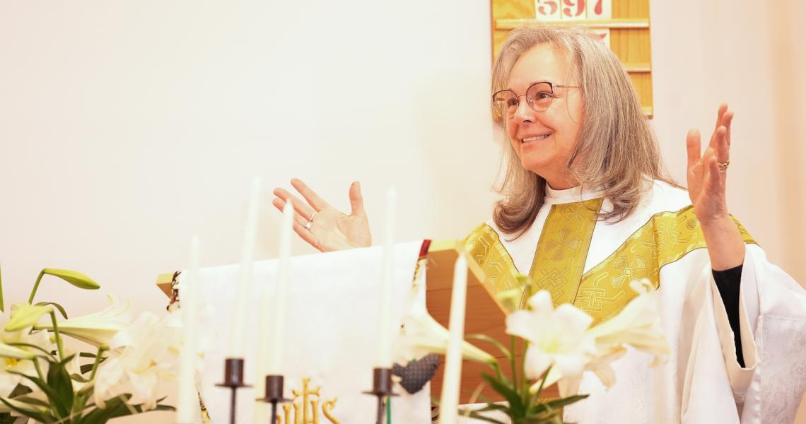 Reverend Patti Johnson stands at a pulpit.