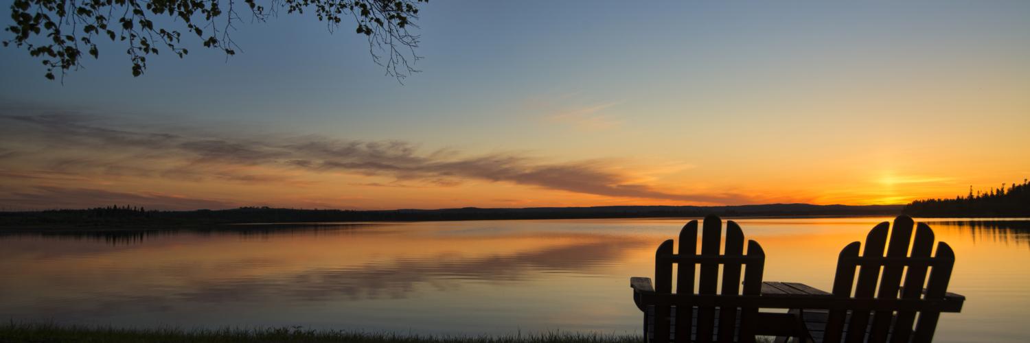 Nature Adirondack chairs on lake sunset