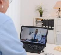 Elderly woman visits with doctor via a laptop