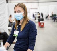 Nurse standing at monitor working at a Essex, VT vaccination Cinic