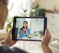 Patient on an iPad, video chatting with a provider.