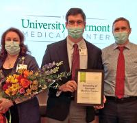 Dr. Leffler, standing with two staff members, of UVM Medical Center holding the 5 Star Award for Patient Safety.