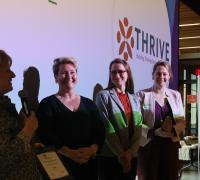 Thrive annual meeting attendees accept Champion Team award.