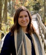 Portrait of Emma Clausen, MD on a bridge in the fall. 