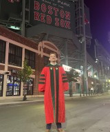 Austin Snyder, MD, in his graduation regalia in front of Fenway Park