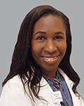 Headshot of a female physician. Dr. Lunmingu has long brown hair and is wearing a blouse under white coat. She is sitting in front of a light grey background.