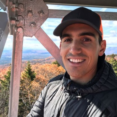 Maguire Testimonial Photo, hat, jacket, outdoors.