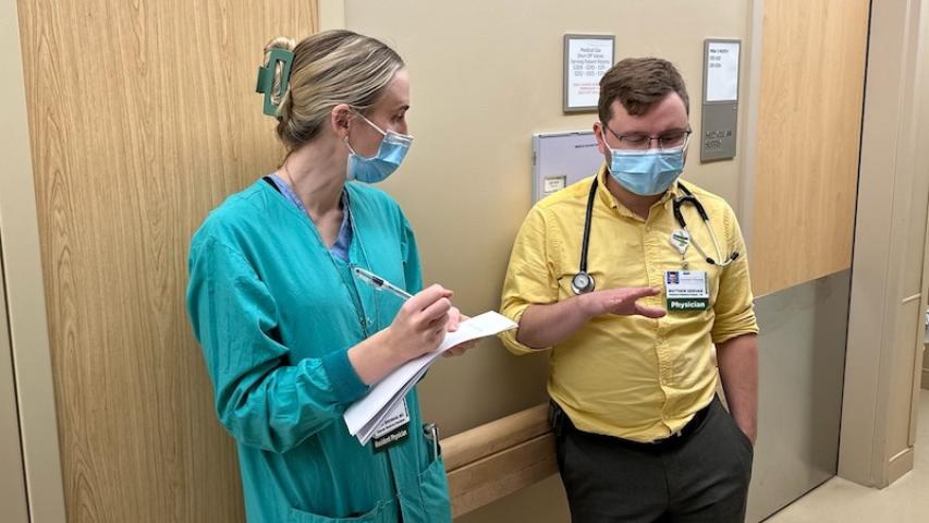 Two masked providers in discussion in clinic
