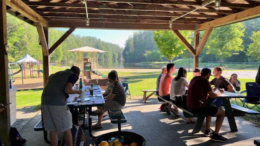 GME Hospice & Palliative Medicine fellows grouped at two picnic tables. 