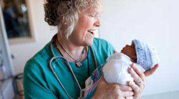 Health care provider holding newborn